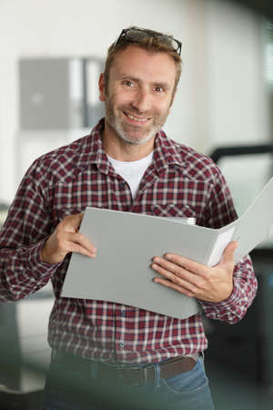 smiling businessman with documents folderの写真素材
