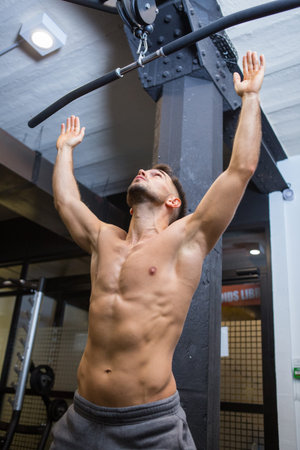 muscle man doing pull-up on horizontal bar