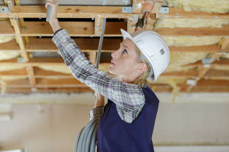 portrait of a woman installing suspended ceilingの写真素材