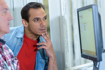 man talking on the phone while working on a laptop
