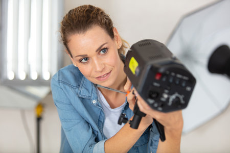 female photographer preparing equipment in the studioの写真素材