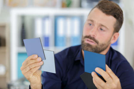 man holding paint color samplesの写真素材