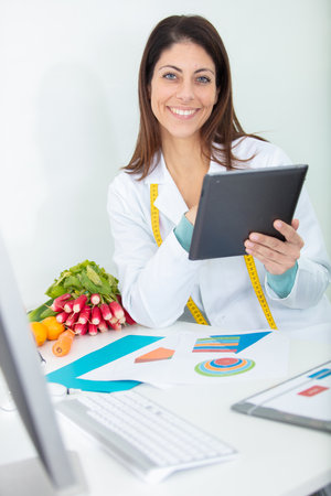 female dietician with tablet giving nutritional adviceの写真素材
