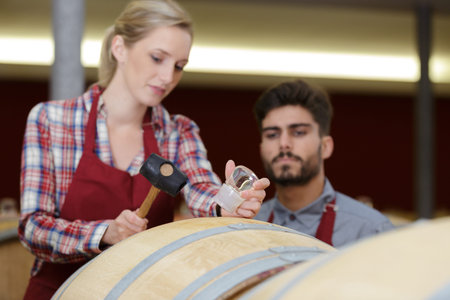 woman and man sommeliers in winery cellar