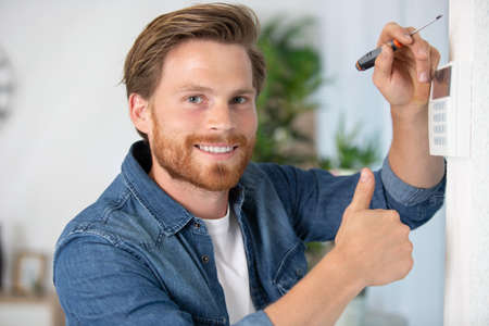 man fixing screw a digital boxの写真素材