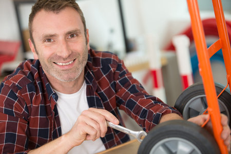 happy man fixing the wheels of a trolley