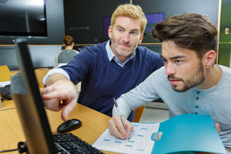 teacher and student in computer room at collegeの写真素材