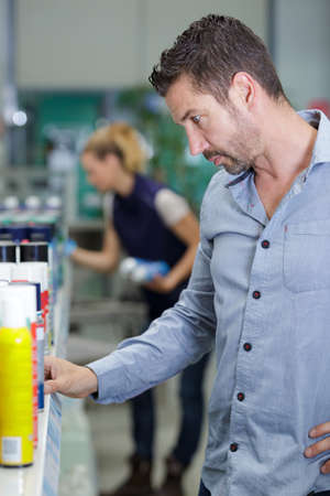 portrait of customer buying spray in shopping mallの写真素材