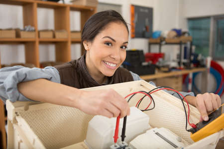 young woman in electronics repair service centerの写真素材
