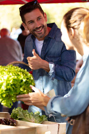 couple buying vegetables on a marketの写真素材