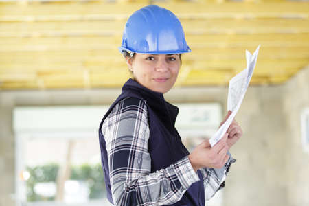 sliming female architect holding paperworkの写真素材