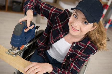 happy woman disable cutting woodの写真素材