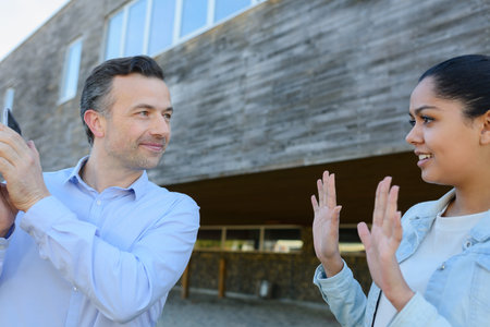 woman communicating through hand gesture to man on the telephone
