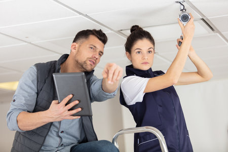 man and woman working on a house ceilingの写真素材