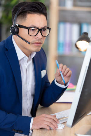 serious asian businessman using a computerの写真素材