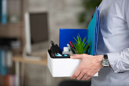 cropped view of person carrying box of workplace possessionsの写真素材