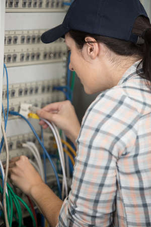 woman works in the server room and switches the wiresの写真素材