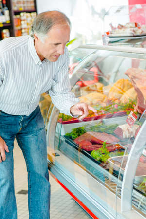 a man is buying meatの写真素材