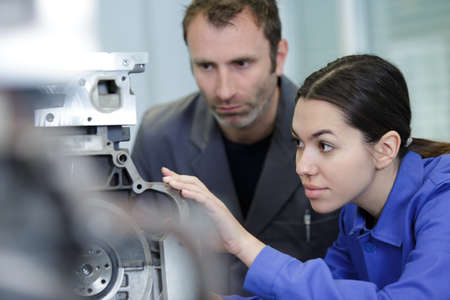 engineer showing equipment to a female apprenticeの写真素材