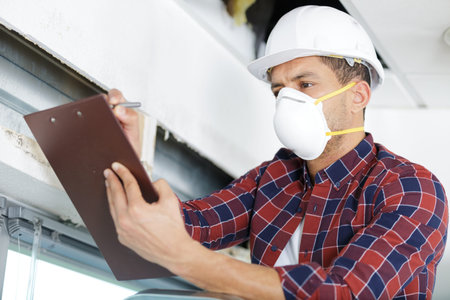 male worker wearing mask writing notes