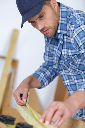 craftsman carpenter measuring wood frameの写真素材