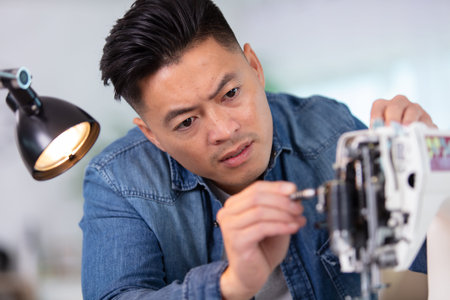 the asian technician repairing electronic device