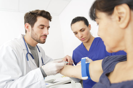 male doctor preparing syringe for female patients armの写真素材