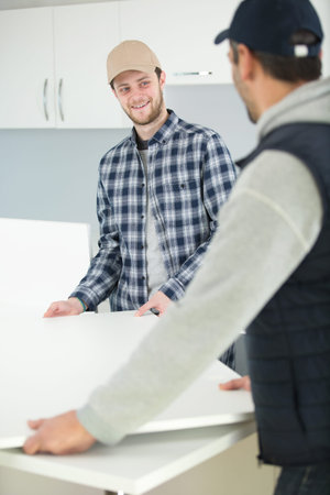 two men having fun when furnishing new house