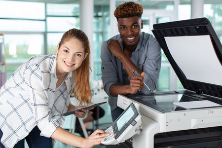 happy two workers and printer maintenanceの写真素材