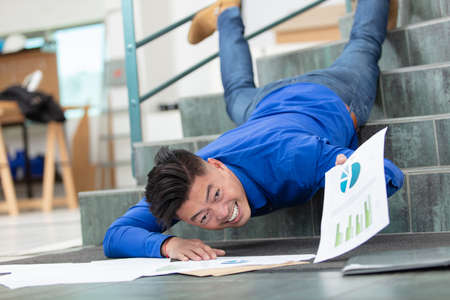 businessman has fallen down the stairs in the workplaceの写真素材