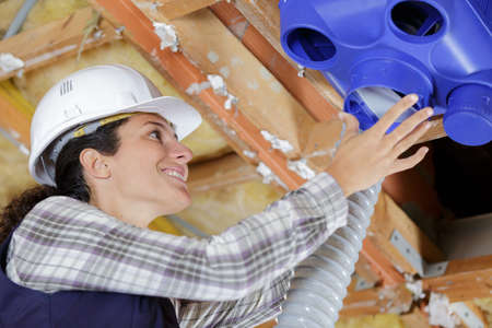a female worker is assembling the ventilation boxの写真素材