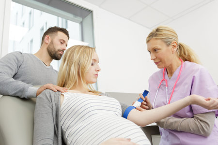 female obstetrician doctor measuring blood sugar of the pregnant womanの写真素材