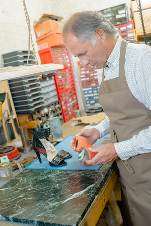 a cobbler examining a shoe