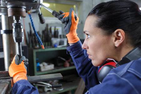 female factory worker working with electric drill