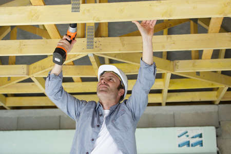 man drilling a new house construction frameの写真素材