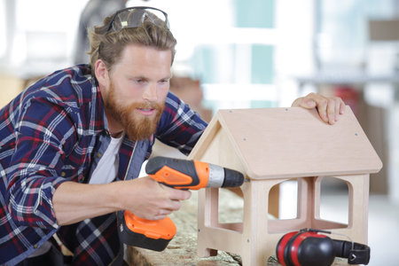a male carpenter drilling wood
