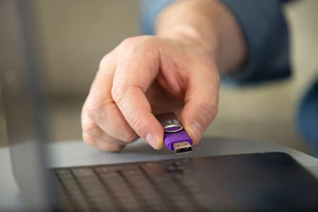 woman hand inserting usb memory stick on computerの写真素材