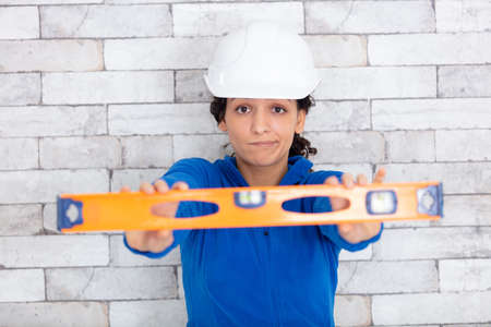 smiling female worker using a spirit levelの写真素材