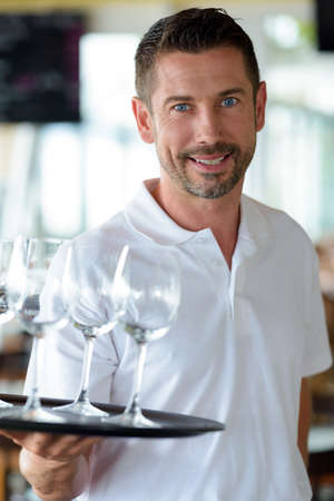 waiter welcomes guests with appetizersの写真素材