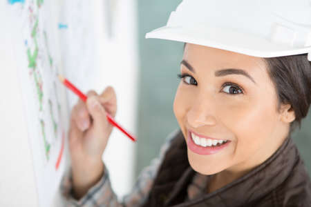 happy female builder writes on the planの写真素材