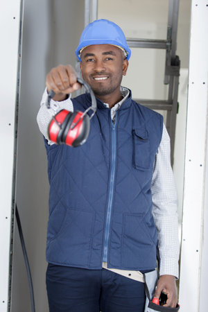 young worker holding noise canceling headphones