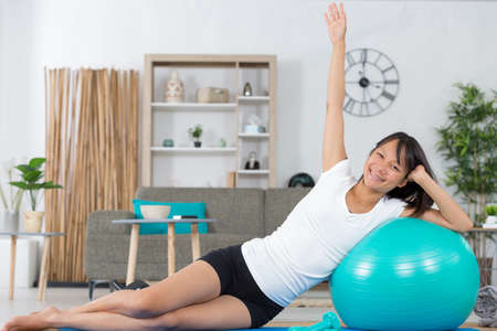 attractive asian lady exercising on an aerobic ballの写真素材