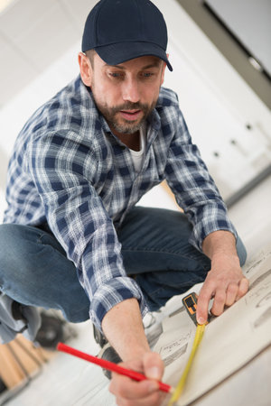man measuring a floor tile