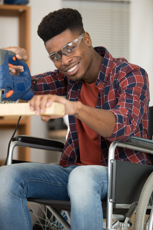 disabled man using electric jigsawの写真素材