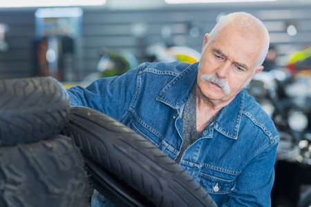 elderly mechanic changing holding wheel