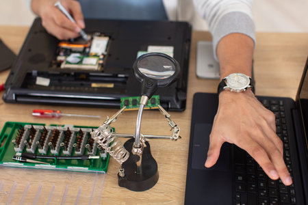 young man repairing motherboard from pc