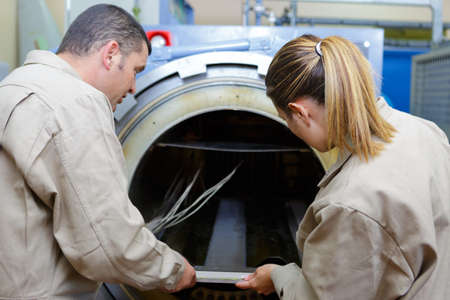 man and woman looking at cylinderの写真素材