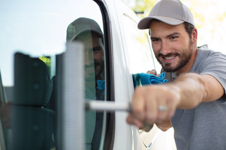 portrait of cheerful delivery person next to the van
