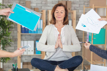 calm young business woman doing yoga exercise at workplace sの写真素材
