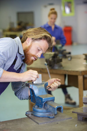 workman securing metal in a vice